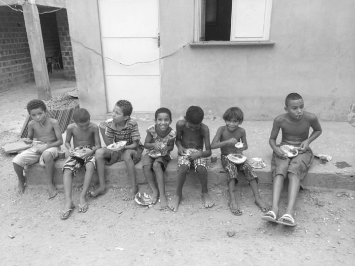 Crianças comendo o que as vezes é a única refeição do dia (Crédito: Reprodução)