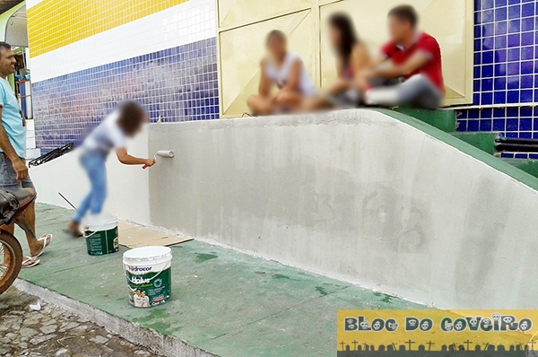 Adolescente passando tinta no muro pichado (Crédito: Reprodução)