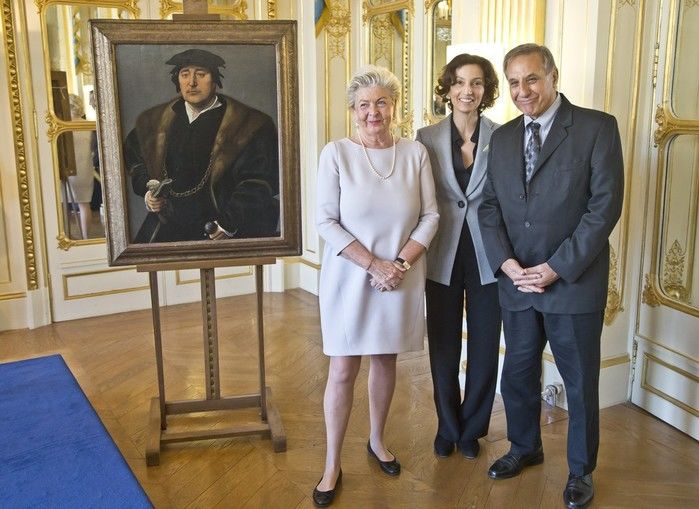 A ministra da Cultura francesa, Audrey Azoulay (centro), posa com Henrietta Schubert e Christopher Bromberg ao lado da pintura de Joos van Cleve em cerimônia no Ministério da Cultura em Paris (Crédito: AFP)