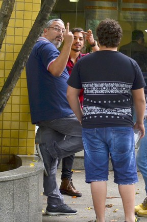 Douglas Sampaio e seu pai fazem gesto obsceno para imprensa (Crédito: Ego)