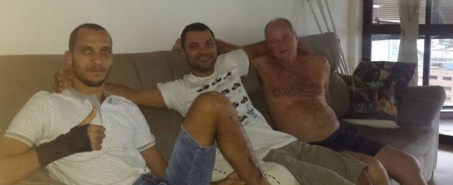 Jogador Neto posa para foto em casa com o irmão e o pai