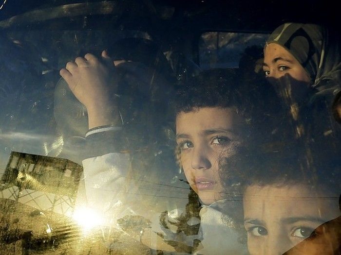 Crianças refugiadas sírias olham através da janela de um carro enquanto cruzam a fronteira do Líbano com suas famílias em Masnaa, no leste do Líbano (Crédito: AP)