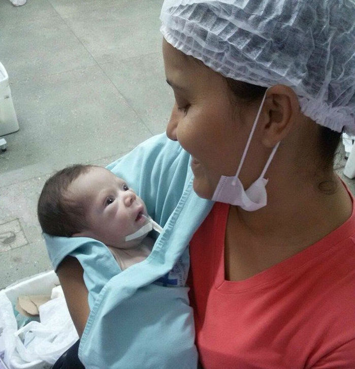 Miguel no colo de sua mãe Olivia Matos (Crédito: Reprodução)