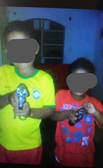 Crianças posam para foto com armas