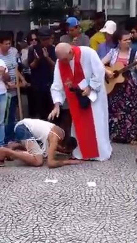 Sheila também beijou pés do padre (Crédito: Reprodução/ Youtube)
