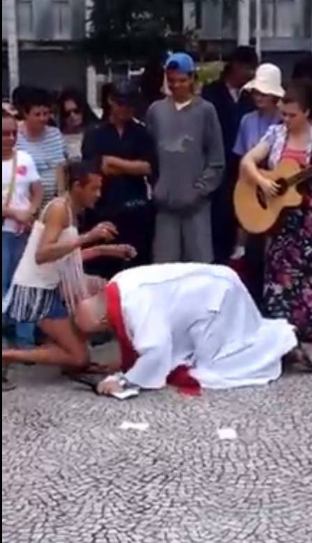 Padre beijou pés da transexual Sheila (Crédito: Reprodução/ Youtube)