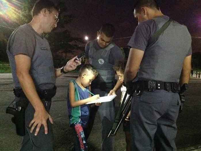 Garoto pede ajuda aos policiais para fazer exercício