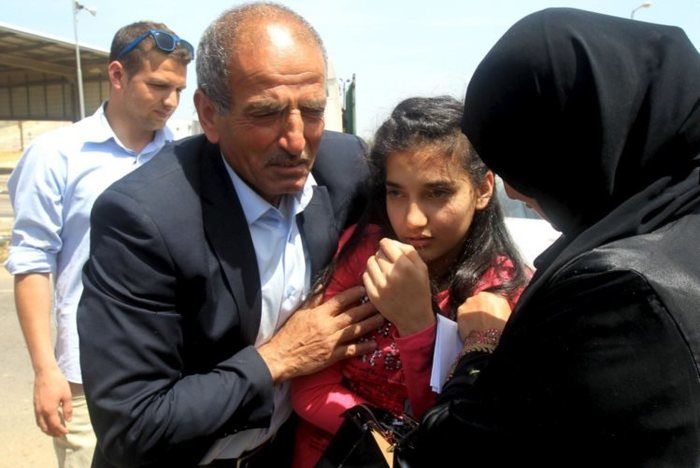 Dima al-Wawi, com os pais, na cidade de Tulkarem, na Cisjordânia, momentos depois de ser libertada (Crédito: JAAFAR ASHTIYEH/AFP )