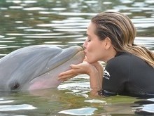 Monique Alfradique realiza sonho de nadar com golfinho em férias