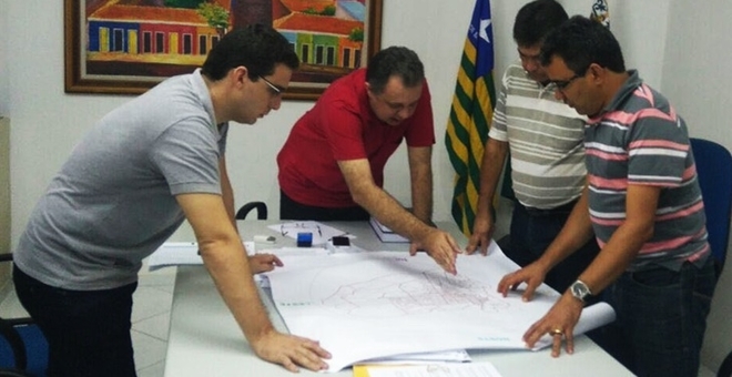 Prefeito e técnicos reunidos visualizam mapa