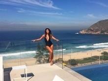 Dani Suzuki usa maiô decotadíssimo e posa em frente a praia no Rio