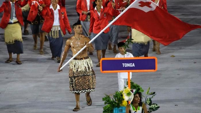 Pita Taufatofua carrega a bandeira de Tonga no desfile das delegações da abertura das Olimpíadas (Crédito: AP)