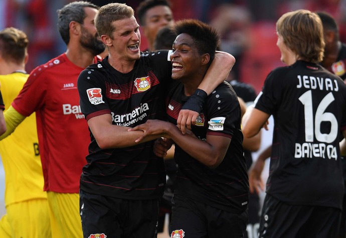 Wendell abraça o volante alemão Lars Bender após vitória do Bayer Leverkusen no Alemão (Crédito: AFP)