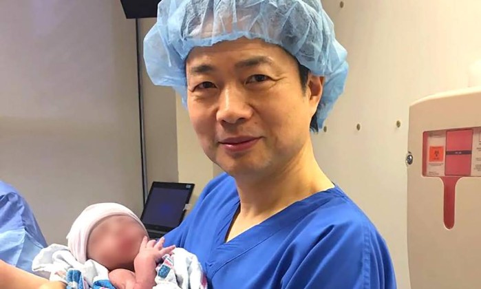 O bebê no colo do médico John Zhang (Crédito: Divulgação)