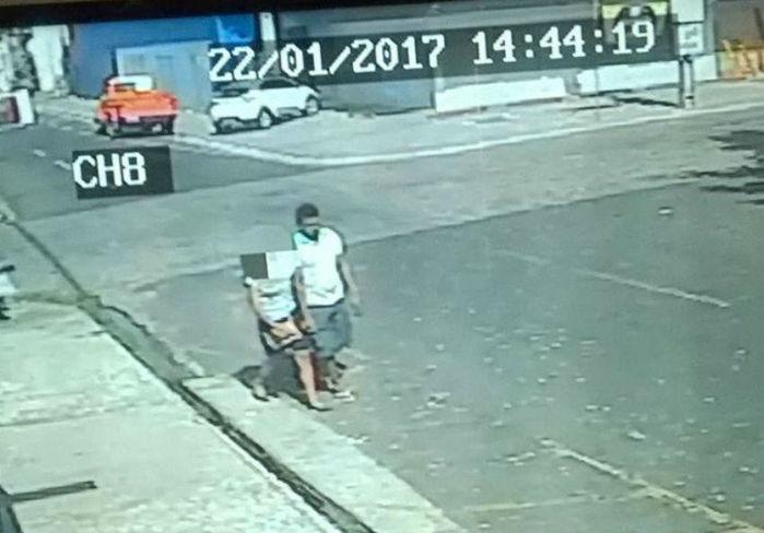 Vítima é obrigada a andar de mãos dadas com criminoso (Crédito: Reprodução)