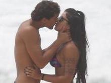 Aline Riscado e Felipe Roque trocam beijos em dia de praia no Rio
