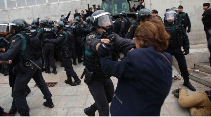 Guarda civil retira separatista que fazia cordão humano em frente a local de votação para garantir a realização do referendo deste domingo (Crédito: Francisco Seco/AP Photo)