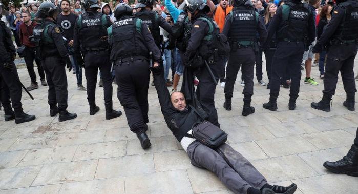 Homem é arrastado por oficiais da Guarda Civil Espanhola no município de Sant Julia de Ramis após fechamento de centro de votação (Crédito: Albert Gea/Reuters)