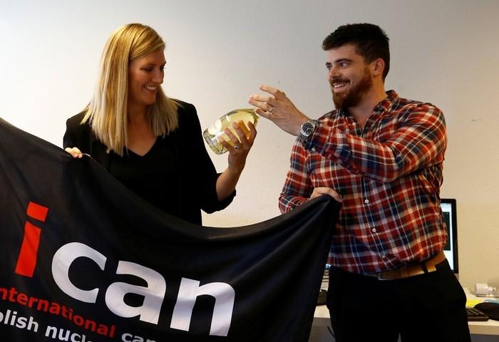 Beatrice Fihn, Diretora Executivo da Campanha Internacional para a Abolição das Armas Nucleares (ICAN), recebe garrafa de champanhe do marido após anúncio do prêmio Nobel de 2017 (Crédito: Denis Balibouse/ Reuters)