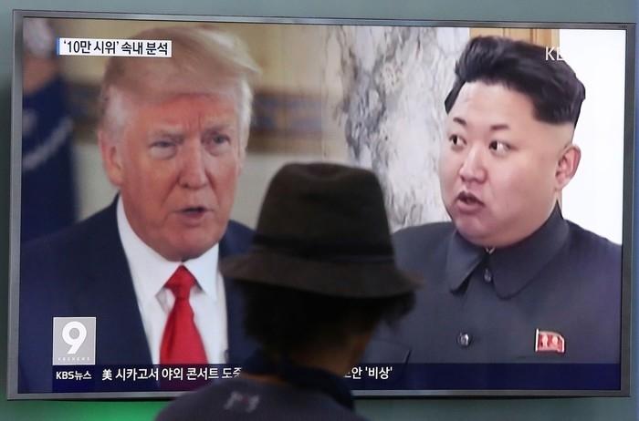 Homem observa imagem do presidente americano, Donald Trump, e do líder norte-coreano, Kim Jong-un, em Seul, na Coreia do Sul (Crédito: AP)