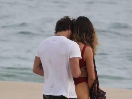 Ator Rômulo Neto é flagrado beijando muito em praia com morena