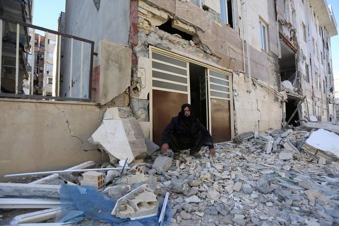 Homem é fotografado sentado sobre destroços (Crédito: Tasnim News Agency/ Reuters))