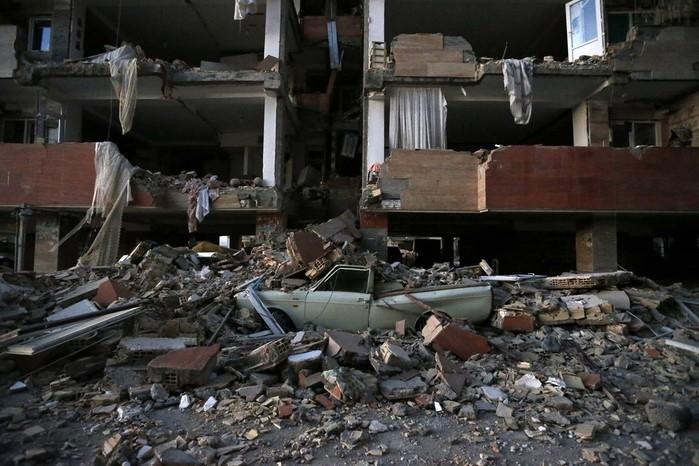 Carro destruído sob destroços (Crédito: Ouria Pakizeh/ISNA/AP)