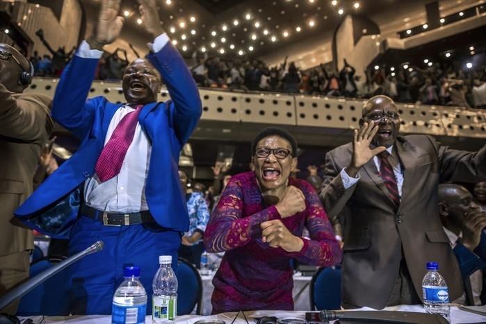 Parlamentares do Zimbábue comemoram a renúncia de Robert Mugabe (Crédito: JEKESAI NJIKIZANA / AFP)