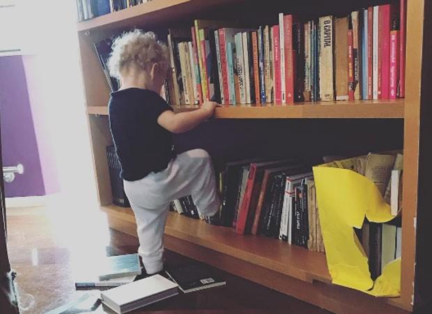 Madalena, filha de Pitty, brinca com estante de livros (Crédito: Reprodução)