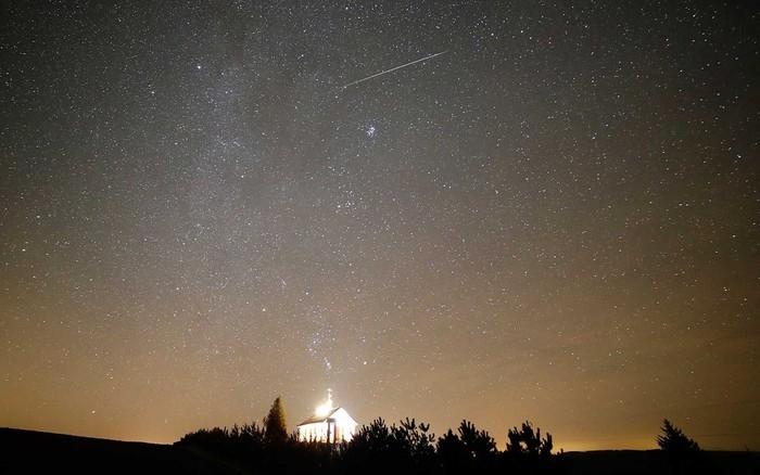 Um meteoro atravessa o céu sobre uma igreja ortodoxa em Zagorie, a 110 km a oeste da capital Minsk, na Bielorrússia (Crédito: Sergei Grits / AP Photo)