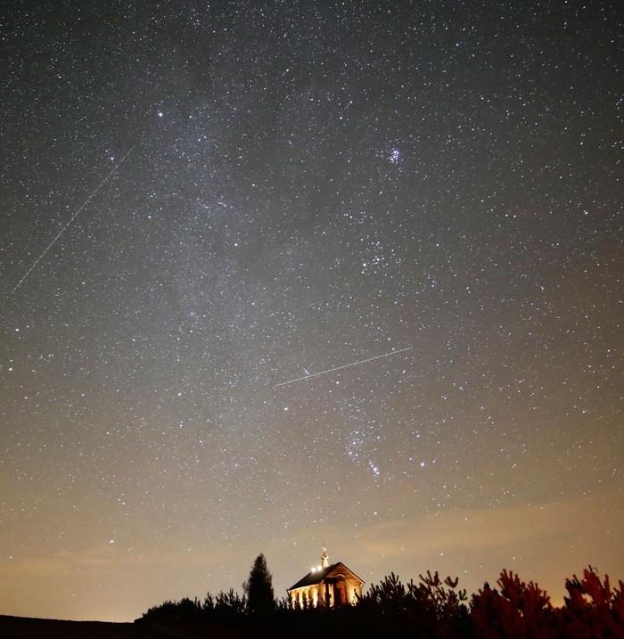 Céu iluminado durante chuva de meteoros da constelação de Gêmeos (Gemínideas) em Zagorie, na Bielorrússia, na noite de quarta-feira (13) (Crédito: Sergei Grits/ AP)
