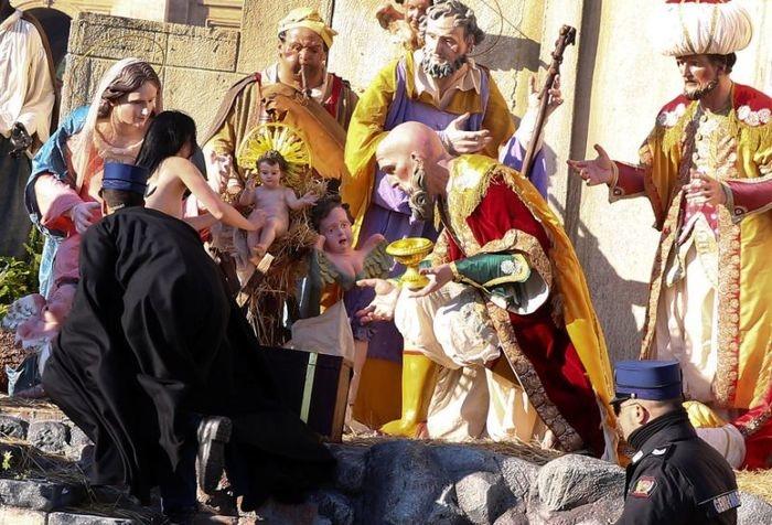 Ativista tenta pegar menino Jesus de presépio (Crédito: Reuters)