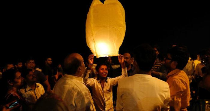 Indianos celebram a chegada de 2018 com uma lanterna em uma praia de Mumbai, na Índia