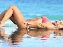 Bella Falconi exibe suas curvas em foto de biquíni deitada na praia