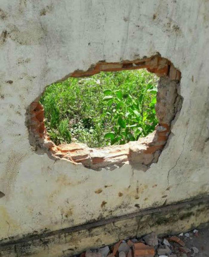 Buraco feito no muro para os detentos fugirem (Crédito: Reprodução)