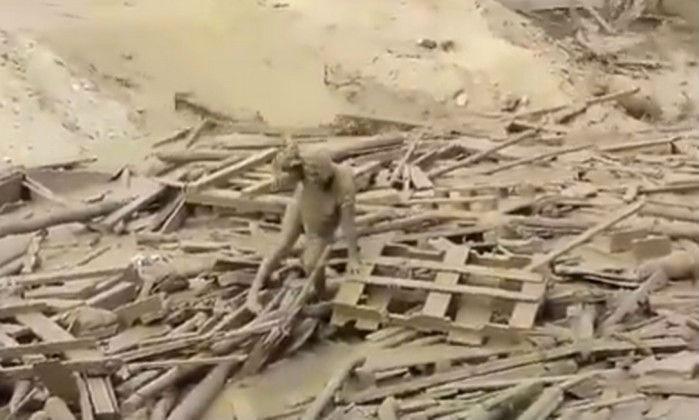 Mulher tenta escapar da enxurrada (Crédito: Reprodução)