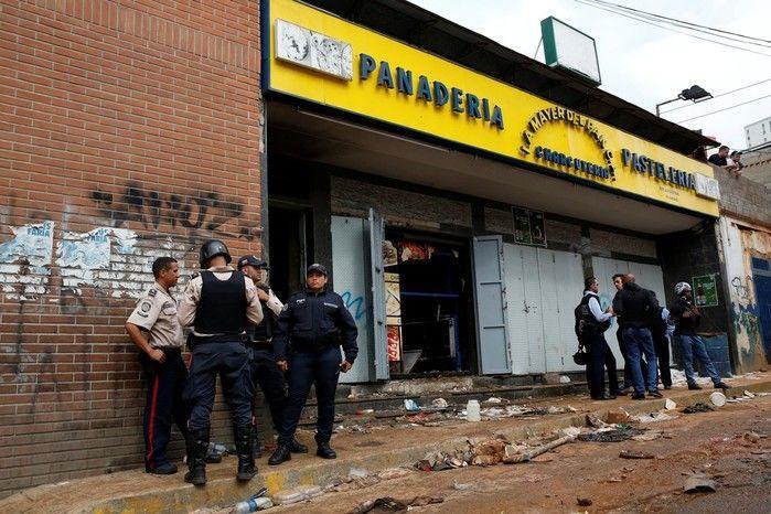 Policiais e investigadores em frente à padaria saqueada em Caracas (Crédito: Reprodução)