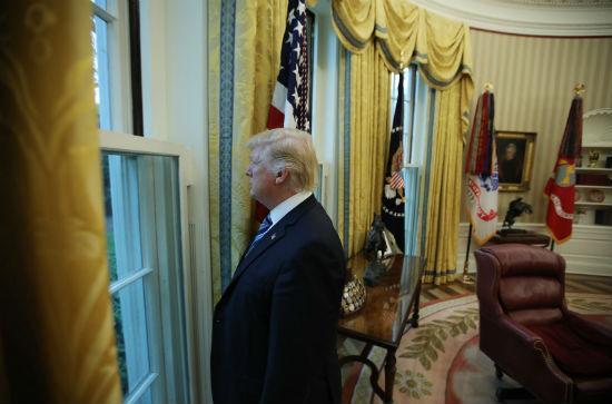 Trump olha pela janela da Casa Branca (Crédito: Reuters)