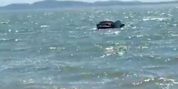 Carro de luxo roubado aparece boiando misteriosamente em lagoa