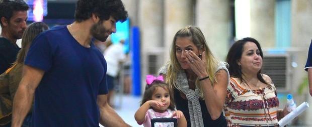 Deborah Secco se emociona ao rever a filha e o marido em aeroporto