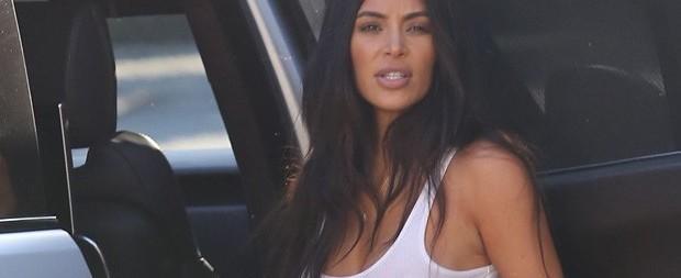 Sem sutiã, Kim Kardashian atrai olhares em passeio com família