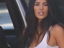 Sem sutiã, Kim Kardashian atrai olhares em passeio com família