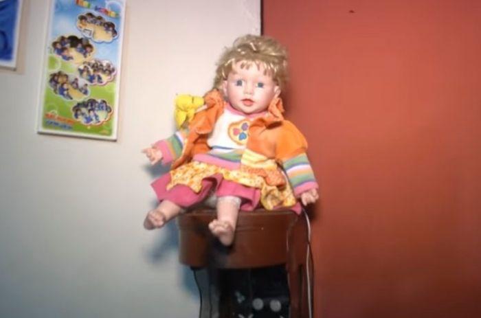Boneca supostamente sai do canto onde deveria permanecer e também canta o Pai Nosso sem ninguém apertar o botão (Crédito: Reprodução)