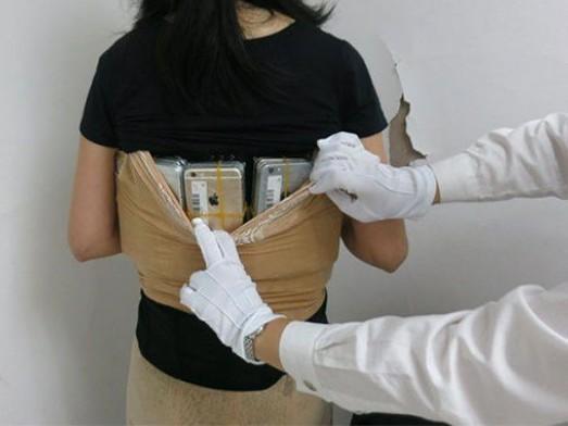 Mulher tenta viajar com 102 iPhones escondidos na roupa e é presa