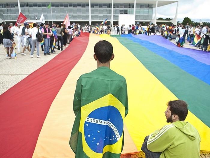Manifestantes da 3ª Marcha Nacional contra a Homofobia ocupam a Praça dos Três Poderes e estendem uma bandeira, com as cores do movimento, em frente ao Palácio do Planalto (Crédito: Marcello Casal Jr/ABr)