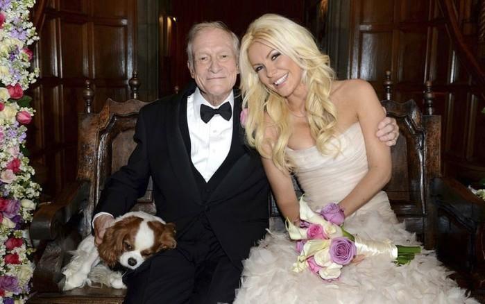 O fundador da 'Playboy', Hugh Hefner, posa com sua nova esposa, a coelhinha Crystal Harris, após o casamento celebrado na Mansão da Playboy, na Califórnia, no último dia de 2012. À esquerda, o cãozinho Charlie também aparece na foto (Crédito: Reuters)