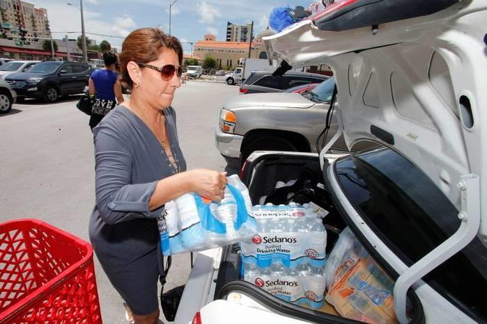 Americana carrega carro com água e suprimentos