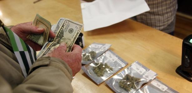 Consumidor compra maconha em uma loja de Oakland no primeiro dia de comercialização da erva legalizada (Crédito: Mathew Sumner/AP Photo)
