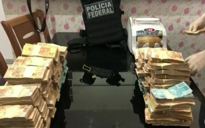 Contagem do dinheiro apreendido com alvos de operação em endereços ligados ao ex-governador de Goiás Marconi Perillo (Crédito: Reprodução/TV Globo)
