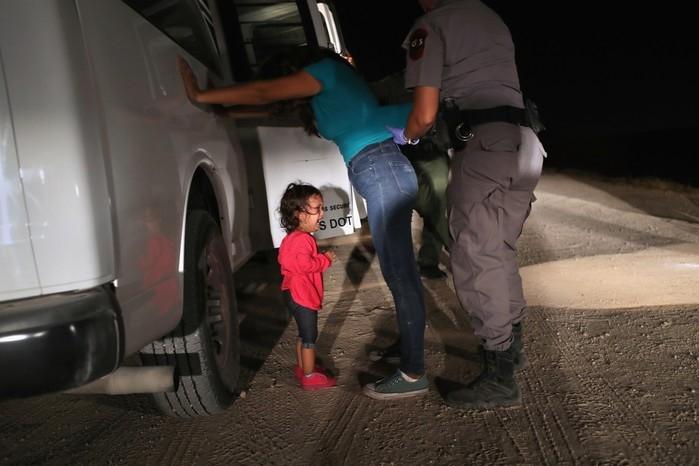 Criança de dois anos chora ao sua mãe ser revistada e detida em McAllen, nos EUA (Crédito: JOHN MOORE / GETTY IMAGES NORTH AMERICA / AFP)